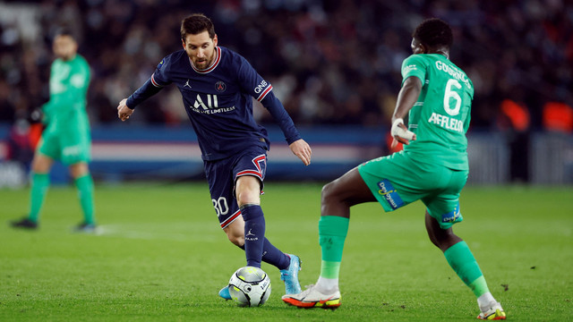 Pemain Paris St Germain Lionel Messi beraksi dengan AS Saint-Etienne Lucas Gourna-Douath di Parc des Princes, Paris, Prancis, Sabtu (26/2/2022). Foto: Christian Hartmann/REUTERS