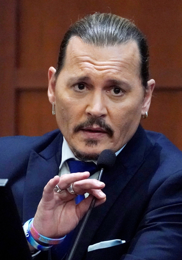 Aktor Johnny Depp memberi kesaksian di ruang sidang selama persidangan pencemaran nama baik terhadap mantan istrinya, Amber Heard, di Fairfax County Circuit Courthouse di Fairfax, Virginia, AS, Senin (25/4/2022). Foto: Steve Helber/Pool via REUTERS