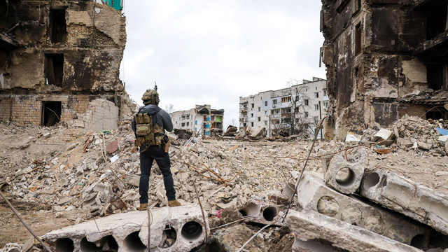 Seseorang berdiri di depan bangunan yang hancur di Kiev, Ukraina, Rabu (13/4/2022). Foto: Polish Presidency/Handout via REUTERS