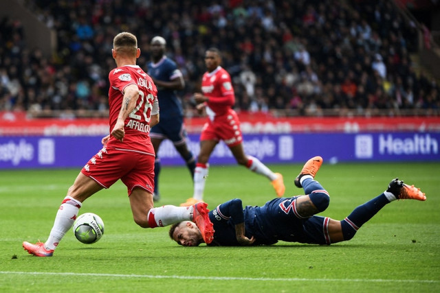 Penyerang Paris Saint-Germain asal Brasil Neymar (tengah) terjatuh di samping bek Monaco Ruben Aguilar pada laga AS Monaco vs Paris Saint Germain (PSG) di Stadion Louis II di Monako pada Minggu (20/3/2022).
 Foto: Clement Mahoudeau/AFP