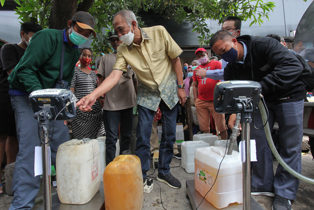Dirjen Perdagangan Dalam Negeri Kementerian Perdagangan Oke Nurwan (tengah) meninjau penjualan minyak goreng curah di Pasar Pucang, Surabaya, Jawa Timur, Senin (21/2/2022). Foto: Didik Suhartono/ANTARA FOTO
