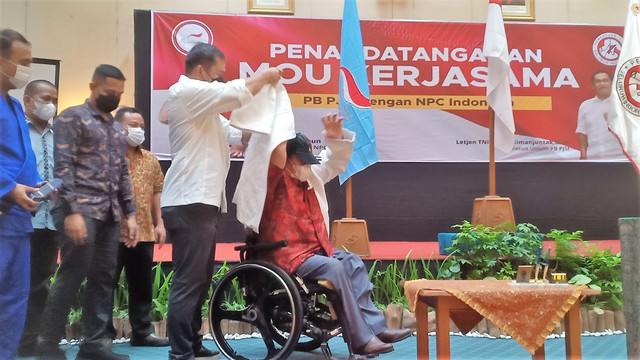 Ketua Umum PB PJSI, Letjen Maruli Simanjuntak, mengenakan baju judo kepada Ketua NPC Indonesia Senny Marbun di sela-sela penandatanganan kerja sama di Hotel Sahud Jaya, Solo, Kamis (05/05/2022). FOTO: Agung Santoso