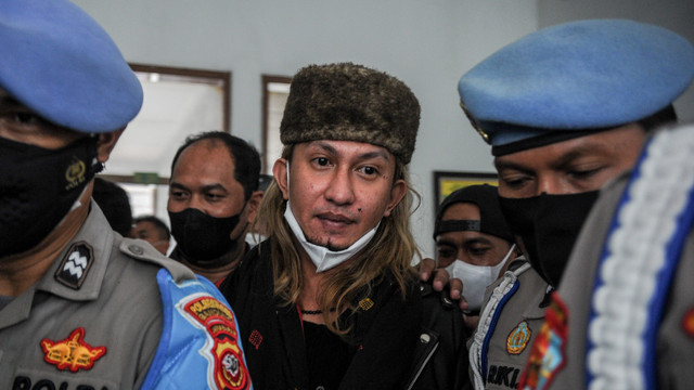 Anggota kepolisian mengawal terdakwa kasus dugaan penyebaran berita bohong Bahar Bin Smith usai menjalani sidang dengan agenda pembacaan eksepsi di Pengadilan Negeri Bandung, Jawa Barat, Selasa (12/4/2022). Foto: Raisan Al Farisi/ANTARA FOTO