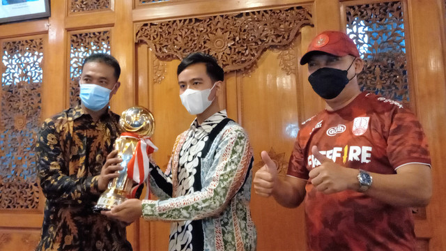 Mantan pelatih Persis Solo, Eko Purdjianto (kiri), menyerahkan Piala Liga 2 kepada Wali Kota Solo Gibran Rakabuming Raka di Rumah Dinas Loji Gandrung. FOTO: Agung Santoso