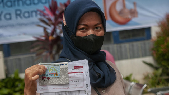 Orang tua menunjukkan bantuan Program Indonesia Pintar (PIP) di Rangkasbitung, Lebak, Banten, Jumat (8/4/2022). Foto: Muhammad Bagus Khoirunas/ANTARA FOTO
