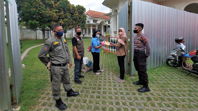 Warga menerima surat keterangan sehat usai menjalani isolasi di Ndalem Priyosuhartan, Solo, Jumat (18/02/2022). FOTO: Fernando Fitusia