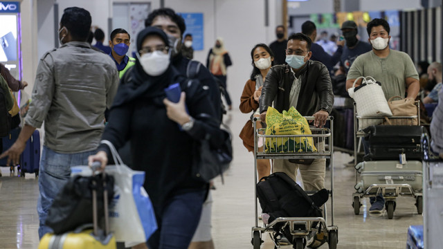 Sejumlah calon penumpang pesawat berjalan di area Terminal 2 Bandara Soekarno Hatta, Tangerang, Banten, Selasa (19/4/2022). Foto: Fauzan/ANTARA FOTO