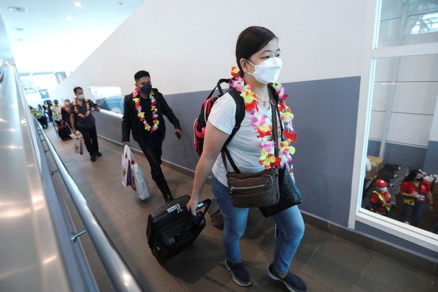 Para pelancong memasuki area Bandara Internasional Kuala Lumpur 2 (KLIA2), Sepang, Selangor, Malaysia, (1/4/2022). Foto: Hasnoor Hussain/REUTERS