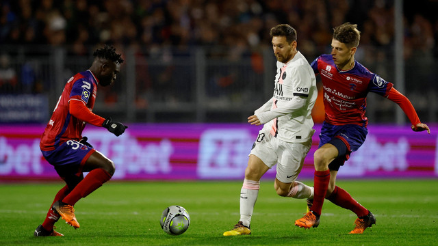 Pemain Paris St Germain Lionel Messi beraksi bersama pemain Clermont Yohann Magnin di Stade Gabriel Montpied, Clermont-Ferrand, Prancis, Sabtu (9/4/2022). Foto: Stephane Mahe/REUTERS