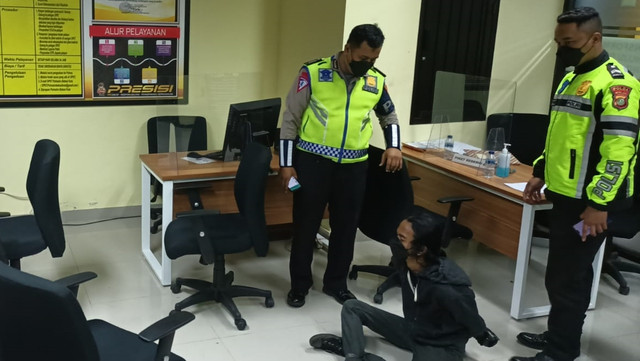 Pelaku pelemparan bom molotov ke Pos Polantas Jatiwarna, saat diamankan polisi, Rabu (16/2/2022). Foto: Dok. Istimewa