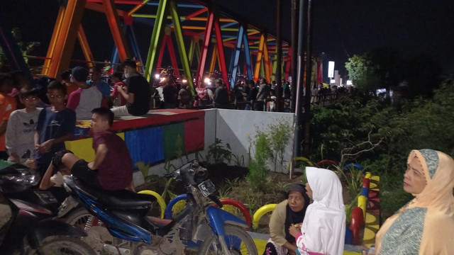 Warga memadati jembatan Sungai Perpil Langon-Mejasem Jumat (18/3/2022) malam. (Foto: Irsyam Faiz)