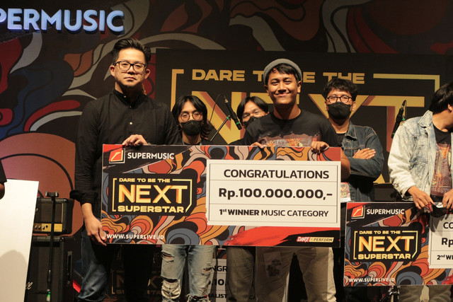 Ronald Steven (kiri) menyerahkan hadiah secara simbolis kepada Juara 1 DTBTNS Season 2 dari kategori musik, yaitu perwakilan personel Mad Elephant. dok: DTBTNS 