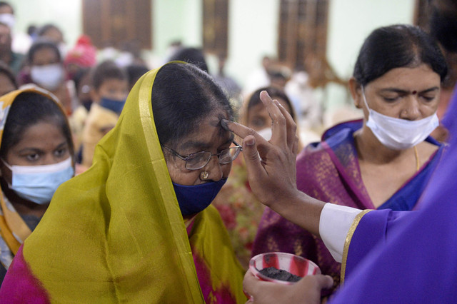Seorang penganut agama Kristen diberikan tanda salib di dahi selama kebaktian Rabu Abu di gereja Saint Anthony di Hyderabad pada Rabu (2/3). Foto: Noah Seelam/AFP