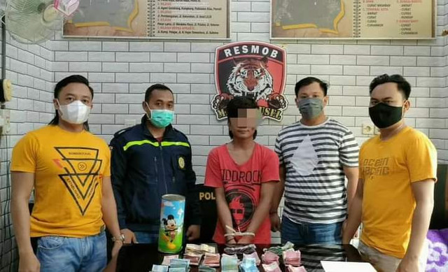 Pelaku bersama barang bukti saat diamankan oleh polisi.
