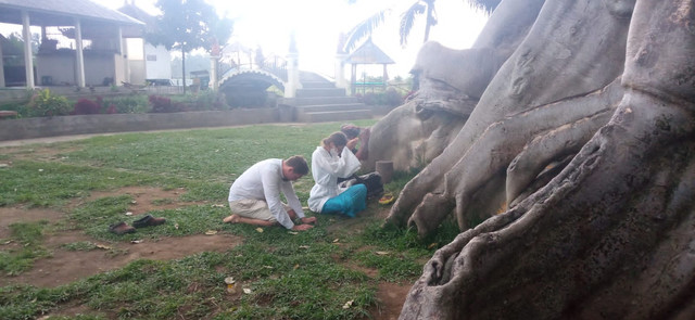 WNA pelaku pose telanjang di pohon sakral saat menyampaikan permohonan maaf - Foto: PC KMHDI Tabanan