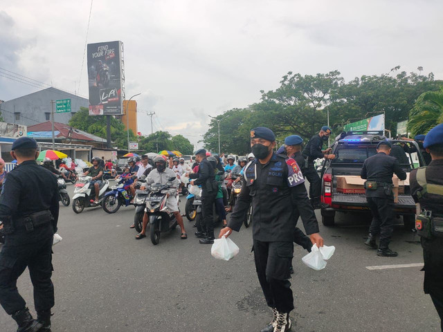 Anggota Brimob Polda Maluku Utara, saat bagi-bagi takjil kepada masyarakat. Foto: Istimewa
