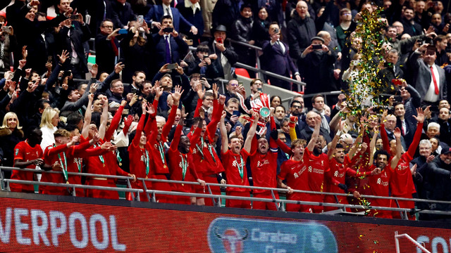 Pemain Liverpool berselebrasi dengan piala setelah memenangkan Piala Carabao di Stadion Wembley, London, Inggris, Minggu (27/2/2022). Foto: David Klein/REUTERS