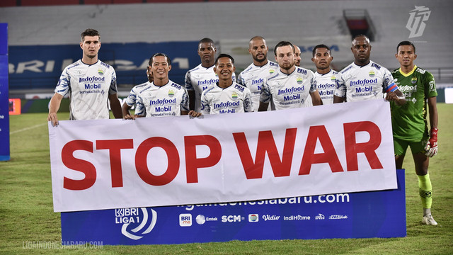 Para pemain Persib memegang banner 'STOP WAR' sebelum pertandingan Liga 1 antara Persija melawan Persib di Stadion Kapten I Wayan Dipta Gianyar Bali, Selasa (1/3/2022). Foto: ligaindonesiabaru.com