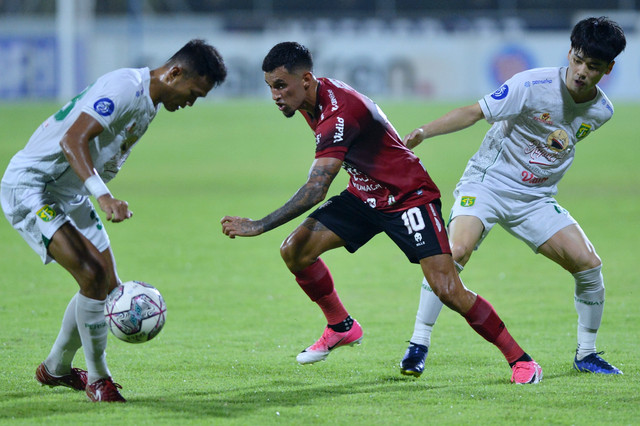 Pemain Bali United Stefano Lilipaly (tengah) berusaha melewati pemain Persebaya Surabaya Taisei Marukawa (kanan) dan Koko Ari Araya (kiri) saat pertandingan Liga 1 di Stadion I Gusti Ngurah Rai, Denpasar, Bali, Jumat (25/3/2022). Foto: Fikri Yusuf/ANTARA FOTO