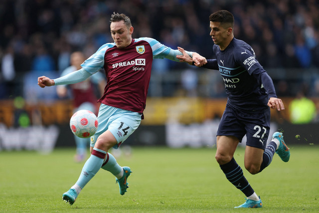 Pemain Burnley Connor Roberts beraksi dengan pemain Manchester City Joao Cancelo di Stadion Turf Moor, Burnley, Inggris, Sabtu (2/4/2022). Foto: Action Images via Reuters/Lee Smith
