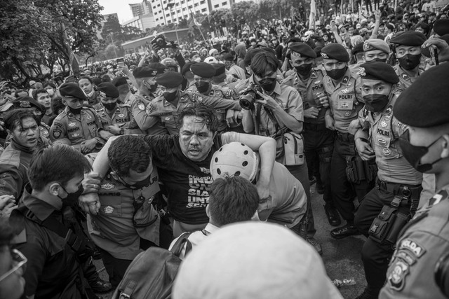 Polisi membawa Ade Armando yang terluka saat demo 11 April di Gedung DPR RI, Jakarta, Senin (11/4/2022). Foto: Aditia Noviansyah/kumparan