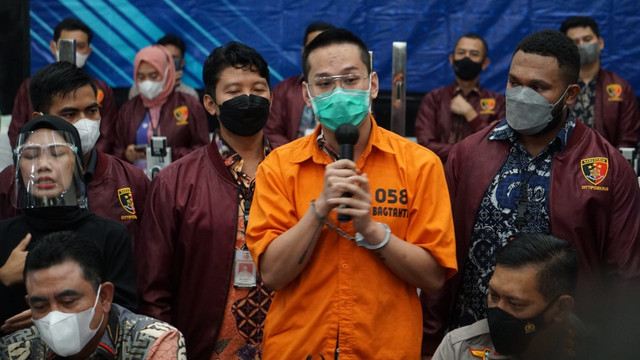 Polisi menunjukkan tersangka kasus penipuan aplikasi Binomo Indra Kenz (tengah) saat konferensi pers di Bareskrim, Mabes Polri Jakarta, Jumat (25/3/2022).
 Foto: Jamal Ramadhan/kumparan