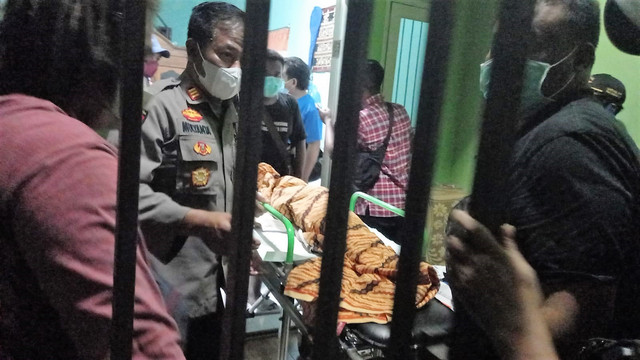 Jenazah korban dibawa polisi ke mobil ambulans untuk keperluan autopsi, Selasa (12/04/2022) malam. FOTO: Agung Santoso