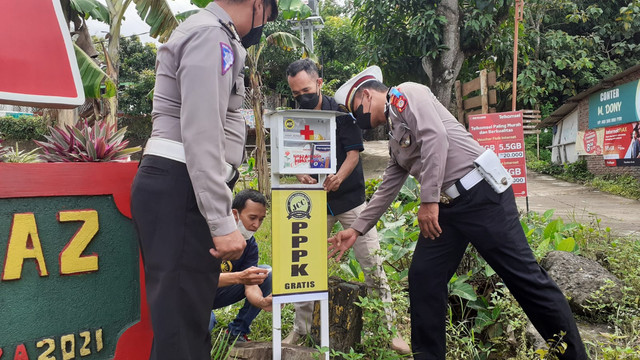 Polres Gunungkidul bersama relawan memasang kotak P3K di Jalan Jogja-Wonosari, Gunungkidul. Foto: erfanto/Tugu Jogja