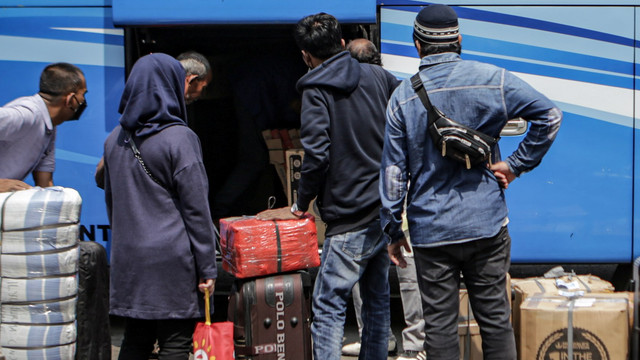 Sejumlah calon penumpang bus memasukkan barang bawaannya ke dalam bagasi bus di Terminal Poris Plawad, Kota Tangerang, Banten, Senin (18/4/2022). Foto: Fauzan/Antara Foto