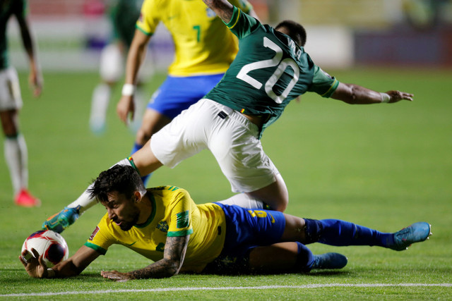 Pemain Brasil Alex Telles berebut bola dengan pemain Bolivia Henry Vaca pada pertandingan kualifikasi Piala Dunia 2022 Zona Conmebol di Estadio Hernando Siles, La Paz, Bolivia. Foto: Manuel Claure/REUTERS