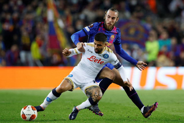 Pemain FC Barcelona Oscar Mingueza berebut bola dengan pemain Napoli Lorenzo Insigne pada pertandingan play off 16 besar Liga Europa di Camp Nou, Barcelona, Spanyol. Foto: Albert Gea/REUTERS