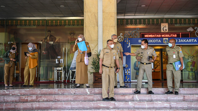 Sejumlah pegawai Aparatur Sipil Negara (ASN) bersiap meninggalkan ruangan pada hari pertama saat bulan Ramadhan 1443 Hijriah di Gedung Balai Kota DKI Jakarta, Senin (4/4/2022).  Foto: M Risyal Hidayat/ANTARA FOTO
