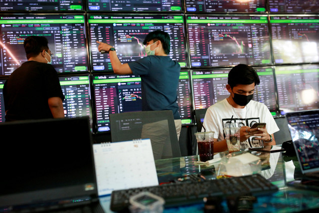 Pengunjung melihat grafik harga terbaru berbagai cryptocurrency. Foto: Soe Zeya Tun/REUTERS