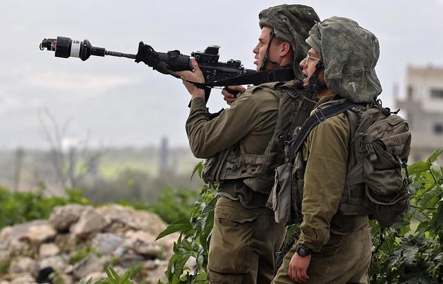 Tentara Israel berjaga-jaga selama protes menentang wilayah pendudukan pada kesempatan Hari Perempuan Internasional di desa Burqa, Tepi Barat, Nablus pada Senin (7/3/2022)
Foto: Jaafar Ashtiyeh/AFP