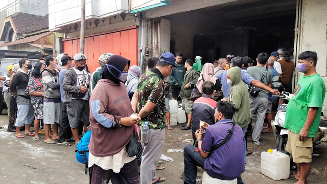 Warga antre membeli minyak goreng curah di salah satu toko kawasan Pasar Legi, Solo, Rabu (23/03/2022). FOTO: Tara Wahyu