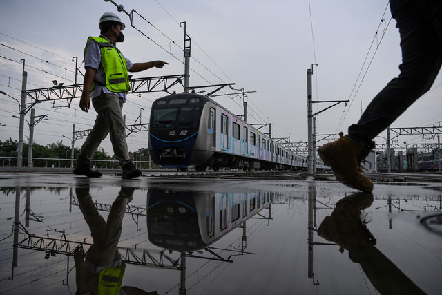 Petugas melintas di deket kereta MRT Ratangga yang siap dioperasikan di Depo MRT Jakarta, Lebak Bulus, Jakarta, Kamis (31/3/2022). Foto: Sigid Kurniawan/Antara Foto