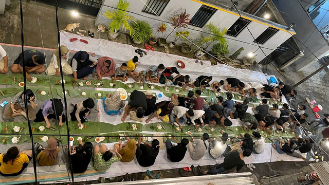 Sahur bareng di jalan Kota Manado dengan beralaskan daun pisang.