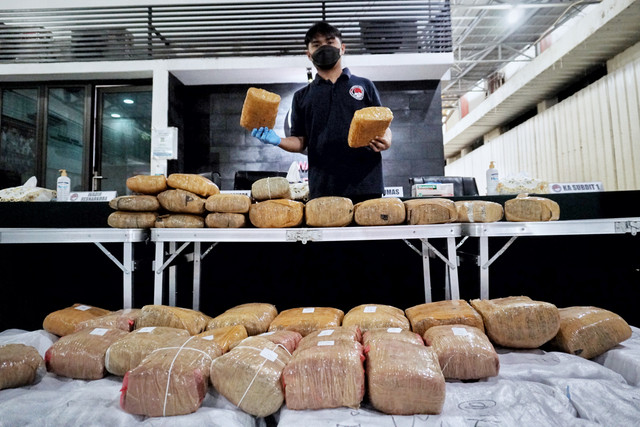 Anggota polisi menata barang ganja saat konferensi pers pengungkapan kasus ganja seberat 471,6 kilogram di Diresnarkoba Polda Metro Jaya, Jakarta, Jumat (22/4/2022).
Foto: Jamal Ramadhan/kumparan