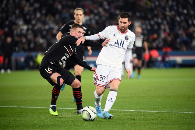 Pemain Paris Saint-Germain (PSG) Lionel Messi berusaha melewati pemain Rennes pada pertandingan lanjutan Liga Prancis di Stadion The Parc des Princes, Paris, Prancis, Jumat (11/2/2022).  Foto: JULIEN DE ROSA / AFP