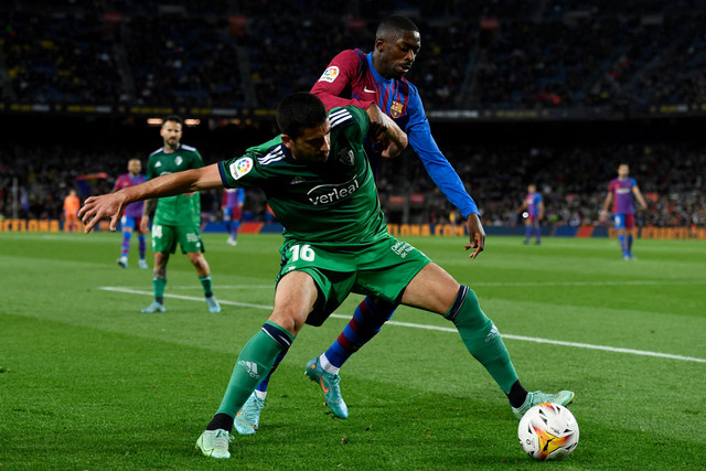 Pemain FC Barcelona Ousmane Dembele berebut bola dengan pemain Osasuna pada pertandingan lanjutan Liga Spanyol di Camp Nou, Barcelona, Spanyol. Foto: Josep LAGO / AFP