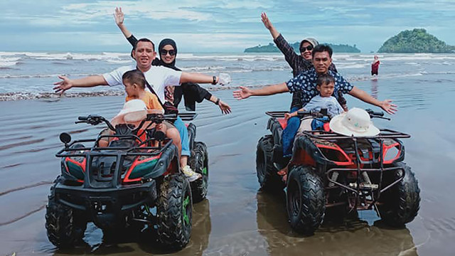 Pengunjung tengah mengendarai RTV di Pantai Air Manis Padang, Sumatera Barat. Foto: dok/Kicky Hengky