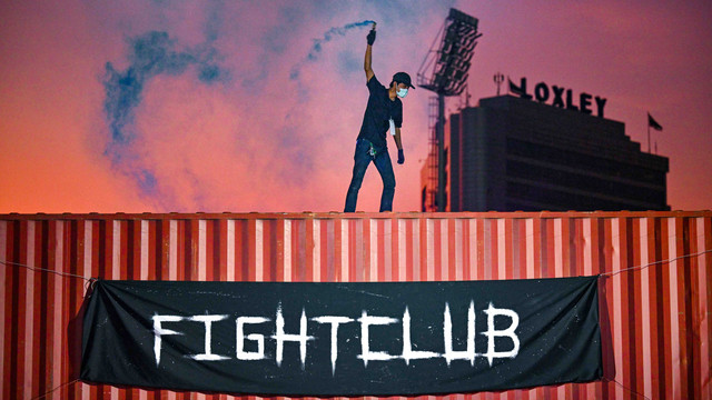 Seorang pria berdiri diatas kontainer di sebuah acara Fight Club di Thailand, Sabtu (16/4/2022). Foto: Lillian SUWANRUMPHA/AFP