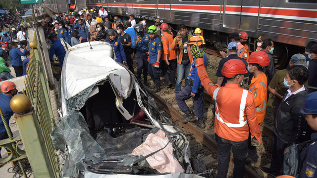 Sejumlah petugas berusaha mengevakuasi mobil Honda Mobilio yang tertabrak KRL Commuterline KA 1077 (Bogor-Jakarta Kota) di kawasan Rawageni, Ratu Jaya, Cipayung, Depok, Jabar, Rabu (20/4/2022). Foto: Andika Wahyu/ANTARA FOTO