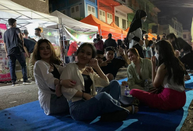 Pengunjung menyantap hidangan kuliner beralaskan karpet di Jambi Night Market. (Foto: M Sobar Alfahri/Jambikita)