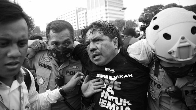 Polisi membawa Ade Armando yang terluka saat demo 11 April di Gedung DPR RI, Jakarta, Senin (11/4). Foto: Aditia Noviansyah/kumparan