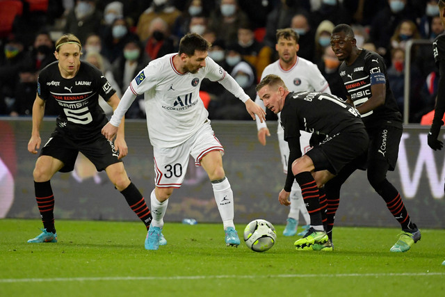 Pemain Paris Saint-Germain (PSG) Lionel Messi berusaha melewati pemain Rennes pada pertandingan lanjutan Liga Prancis di Stadion The Parc des Princes, Paris, Prancis, Jumat (11/2/2022).  Foto: JULIEN DE ROSA / AFP