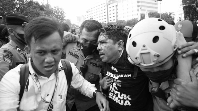 Polisi membawa Ade Armando yang terluka saat demo 11 April di Gedung DPR RI, Jakarta, Senin (11/4). Foto: Aditia Noviansyah/kumparan