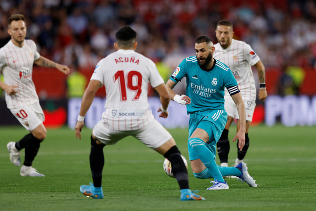 Pemain Real Madrid Karim Benzema berusaha melewati pemain Sevilla pada pertandingan lanjutan Liga Spanyol di Stadion Ramon Sanchez Pizjuan, Seville, Spanyol. Foto: Marcelo Del Pozo/REUTERS