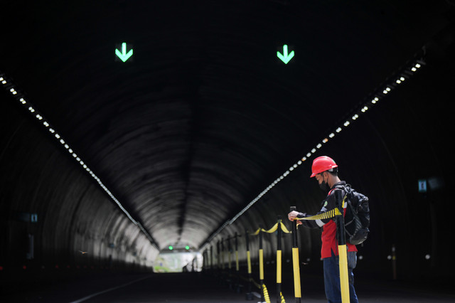 Petugas memasang pembatas di terowongan Jalan Tol Cileunyi-Sumedang-Dawuan (Cisumdawu) di Rancakalong, Kabupaten Sumedang, Jawa Barat, Jumat (22/4/2022). Foto: Raisan Al Farisi/ANTARA FOTO