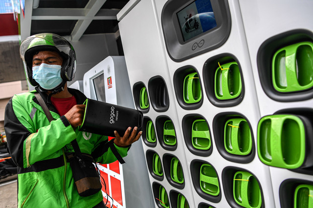 Seorang pengemudi ojek daring menukar baterai sepeda motor listrik dengan yang sudah penuh terisi di Stasiun Penukaran Baterai Kendaraan Listrik Umum (SPBKLU) di SPBU Pertamina, Jalan MT Haryono, Jakarta, Jumat (4/3/2022). Foto: M Risyal Hidayat/Antara Foto